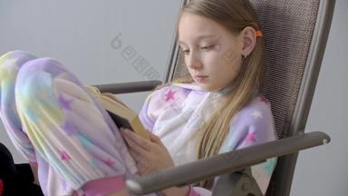 集中少年女孩睡衣阅读书椅子年轻的女学生首页衣服阅读书坐着椅子首页