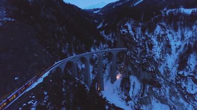 landwasser高架桥铁路火车冬天<strong>晚上</strong>瑞士阿尔卑斯山脉瑞士山<strong>森林</strong>河空中视图无人机苍蝇向前相机倾斜