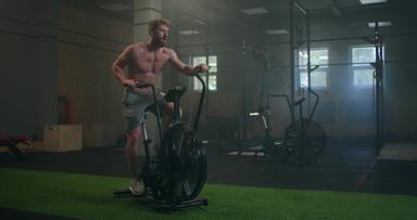 男人。锻炼自行车健身房骑自行车培训健身健身男性空气自行车有氧运动锻炼运动女孩锻炼设备现代黑暗健身房