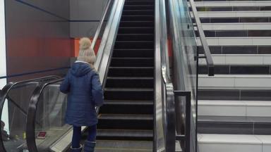 年轻的女孩少年骑自动扶梯现代购物购物中心机场