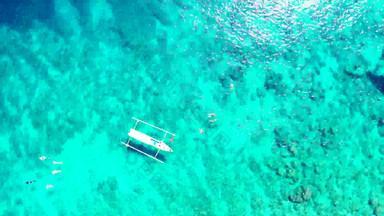 宽角开销旅游拍摄白色桑迪天堂海滩蓝色的水背景色彩鲜艳的