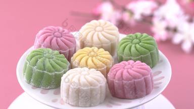 色彩斑斓的雪皮肤月亮蛋糕甜蜜的雪月饼传统的风味极佳的甜点中秋节日柔和的苍白的粉红色的背景关闭生活方式