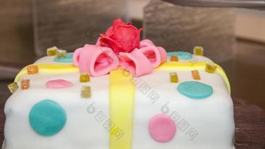 色彩斑斓的白色蛋糕粉红色的玫瑰黄色的弓