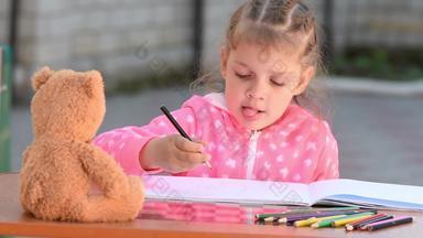五年女孩热情吸引了泰迪熊坐着前面自愿的棒舌头