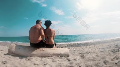 浪漫的夫妇<strong>坐</strong>着海滩<strong>拥</strong>抱享受假期