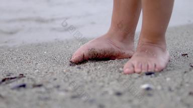 婴儿脚站海滩沙子波洗脚