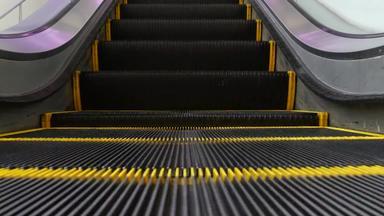 低角毛圈的角度来看视图现代<strong>自动</strong>扶梯楼梯<strong>自动</strong>化<strong>电梯</strong>机制黄色的行楼梯照亮紫色的光未来主义的空机械楼梯移动直