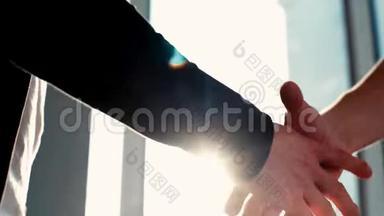 特写两位商务男士握手的日出背景..