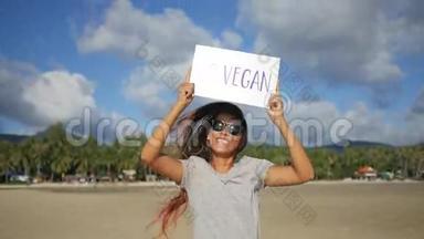 年轻快乐女孩与去素食健康饮食<strong>宣传</strong>标志海滩。 <strong>泰国</strong>Koh Phangan。 高清慢速运动。