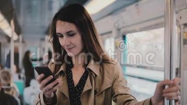 高加索女人在地铁里用智能手机。 美丽幸福青年上班族从手机<strong>APP</strong>上阅读<strong>新闻</strong>.. 5G. 4K