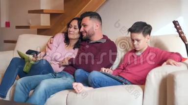 家庭在家看电视和使用数码平板电脑