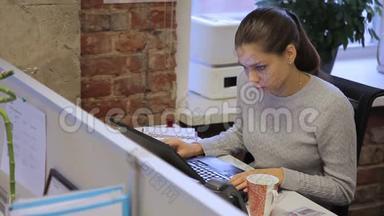 女秘书正坐在领导公司的桌旁，手提电脑。
