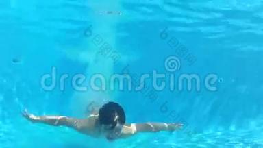 男孩跳入游泳池，然后在水下游泳摄像