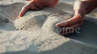 下面的动作，结束：沙子穿过一个年轻女人的手指。 沙子穿过<strong>了</strong>一个