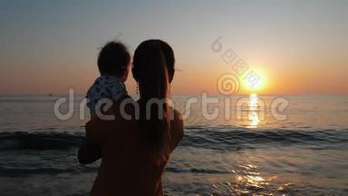 母亲抱着婴儿，看着<strong>海边</strong>或<strong>海边</strong>的日落。