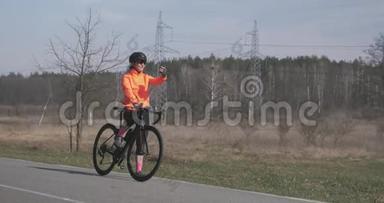 女骑自行车的人在电话里自拍。 骑自行车的女人在智能手机上拍照。 戴着自行车头盔的女孩拍照。 Spo