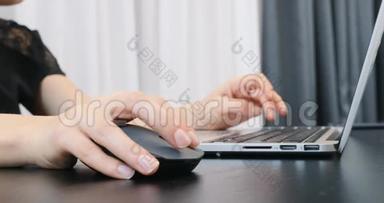 不认识的女人手在笔记本电脑键盘和鼠标上工作。 用手指在电脑键盘上打字