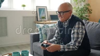 快乐的老人独自玩电子游戏，在家玩游戏