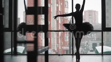剪影。 <strong>芭蕾</strong>舞演员穿着黑色的<strong>芭蕾</strong>舞裙在城市的背景上跳舞。 穿着尖鞋的美丽<strong>芭蕾</strong>