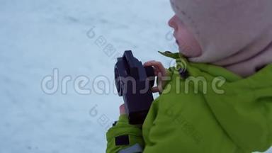 在公园的冬天，孩子们用遥控器控制玩具车。
