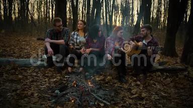 黑暗森林的露营地，年轻的游客用吉他<strong>唱歌</strong>