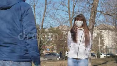 冠状病毒。 戴着<strong>防护</strong>面具的年轻女孩和戴着<strong>防护</strong>面具的男人在街上相遇。 大流行冠状病毒。 游客