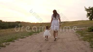 妈妈和孩子互相牵着`的手，晚上在<strong>公园里散步</strong>。 一个穿着白色裙子的小女儿在<strong>散步</strong>