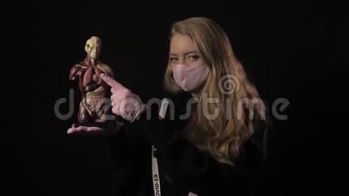 戴着粉红色面具的女孩和一<strong>条带</strong>着铭文的丝<strong>带</strong>，在人体解剖模型上指向肺部