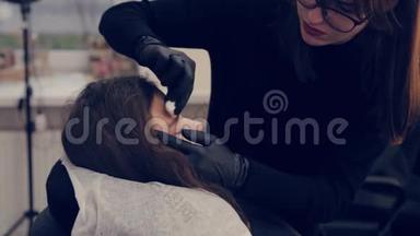 专业女眉师傅在美容院给客户清洗眉毛。