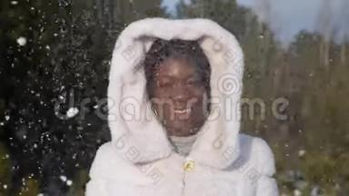 波光粼粼的雪地下，非裔美国妇女摆姿势微笑
