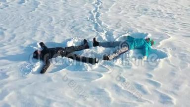 一家人在森林<strong>的</strong>空地上做一个<strong>雪天</strong>使<strong>的</strong>身影。 一个女孩和一个男孩躺在空中摄影