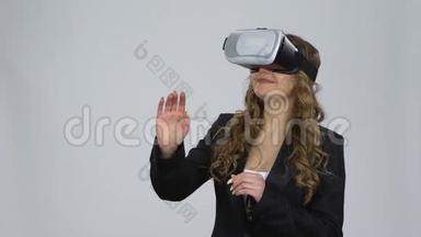 在演播室的灰色背景上戴着虚拟现实眼镜的女人。