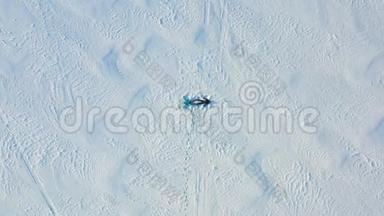 一家人在森林的空地上做一个<strong>雪天</strong>使的身影。 一个女孩和一个男孩躺在空中摄影