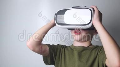 手上有伤疤的男孩在白色背景上使用虚拟现实耳机头盔。 虚拟现实。 虚拟现实眼镜。 新欢