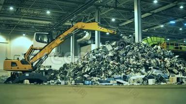 垃圾，垃圾，废品回收厂.. 挖掘机正在室内垃圾场工作