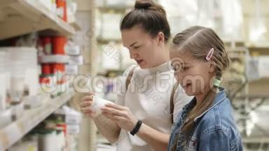 漂亮的女人买室内用品，妈妈和孩子一起在超市里挑选产品，一家人在超市里购物