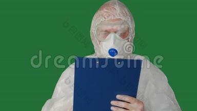 医务人员穿着防护服装，在<strong>夹板</strong>上书写口罩。 穿着安全套装的男子在<strong>夹板</strong>上写面具