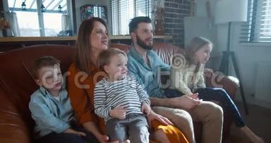 家庭幸福的肖像，年轻微笑的白种人<strong>爸爸妈妈</strong>和<strong>孩子</strong>们一起看电视玩得很开心。
