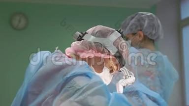 手术期间的手术团队.. 外科医生是一个友好的团队，蓝色现代手术室的专业人士