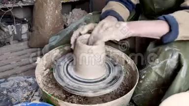 陶工的手放在陶轮特写上。 古老的传统艺术，手工制作，粘土和陶瓷制作.. 陶器车间