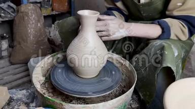 陶工的手放在陶轮特写上。 古老的传统艺术，手工制作，粘土和陶瓷制作.. 陶器车间