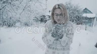 戴着眼镜、穿着毛衣、戴着手套的女孩站在冬天降雪下的街道上