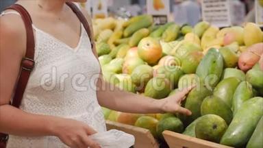 漂亮的年轻女人正在超市里买东西，在超市里选择烹饪产品，健康