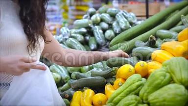 漂亮的年轻女人或妈妈正在超市里买东西，在超市里选择做饭的产品