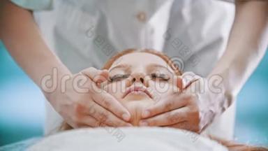 按摩-按摩师用手掌揉捏一位年轻女子的颈部区域