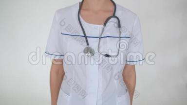 一个年轻的医学女孩用听诊器把她的手臂折叠在胸前，女孩`脸是看不见的。 儿科医生