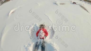 一个小男孩做一个雪天使。 冬季娱乐概念。 慢镜头