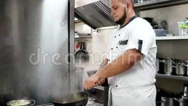厨师将酒精倒入锅中点燃，在酒店或餐厅的厨房里准备油炸食品