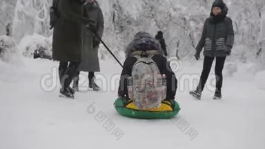 学生们在冬天在学校附近下课后玩得很开心。 同学在雪地里互相滚来滚去做油管