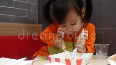 亚洲同胞小女孩喜欢吃<strong>炸鸡</strong>，薯条和花蜜在服务商店与她的家人。 <strong>肯德基</strong>是一家